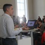 A student presents his project in front of a large audience