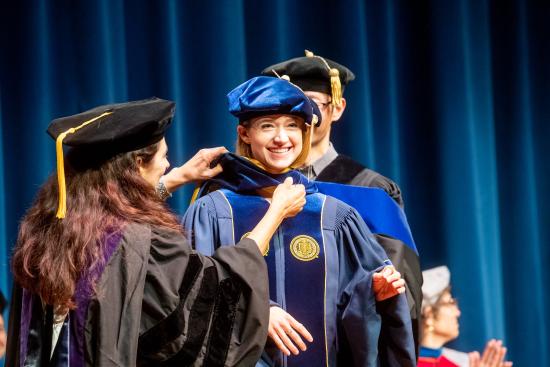 Ph.D. alumna Elaine Sedenberg is hooded by her faculty advisors (Noah Berger Photography)